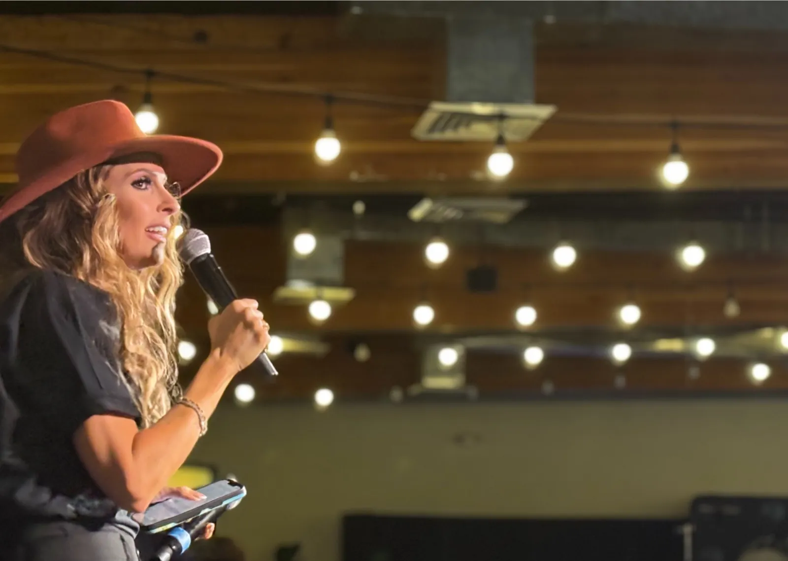 Carrie Hill raising the mic on stage