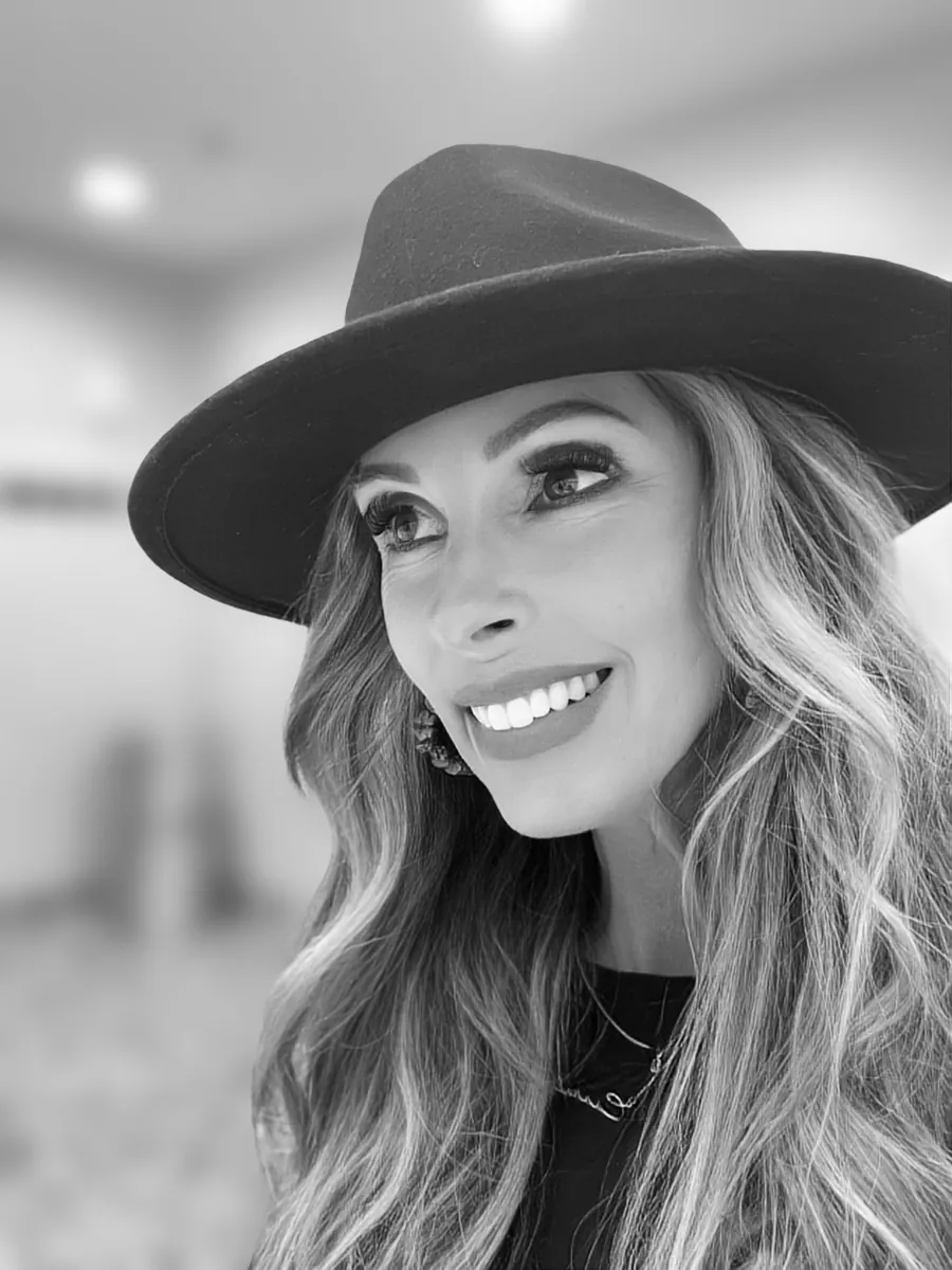 Black and white portrait of keynote speaker Carrie Hill wearing a hat