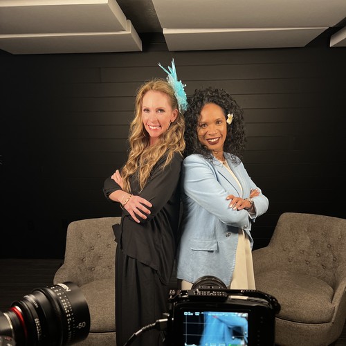 Two women posing back-to-back in studio